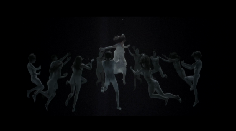 a still from the horror movie the lodgers.  a young girl floats underwater surrounded by ghosts